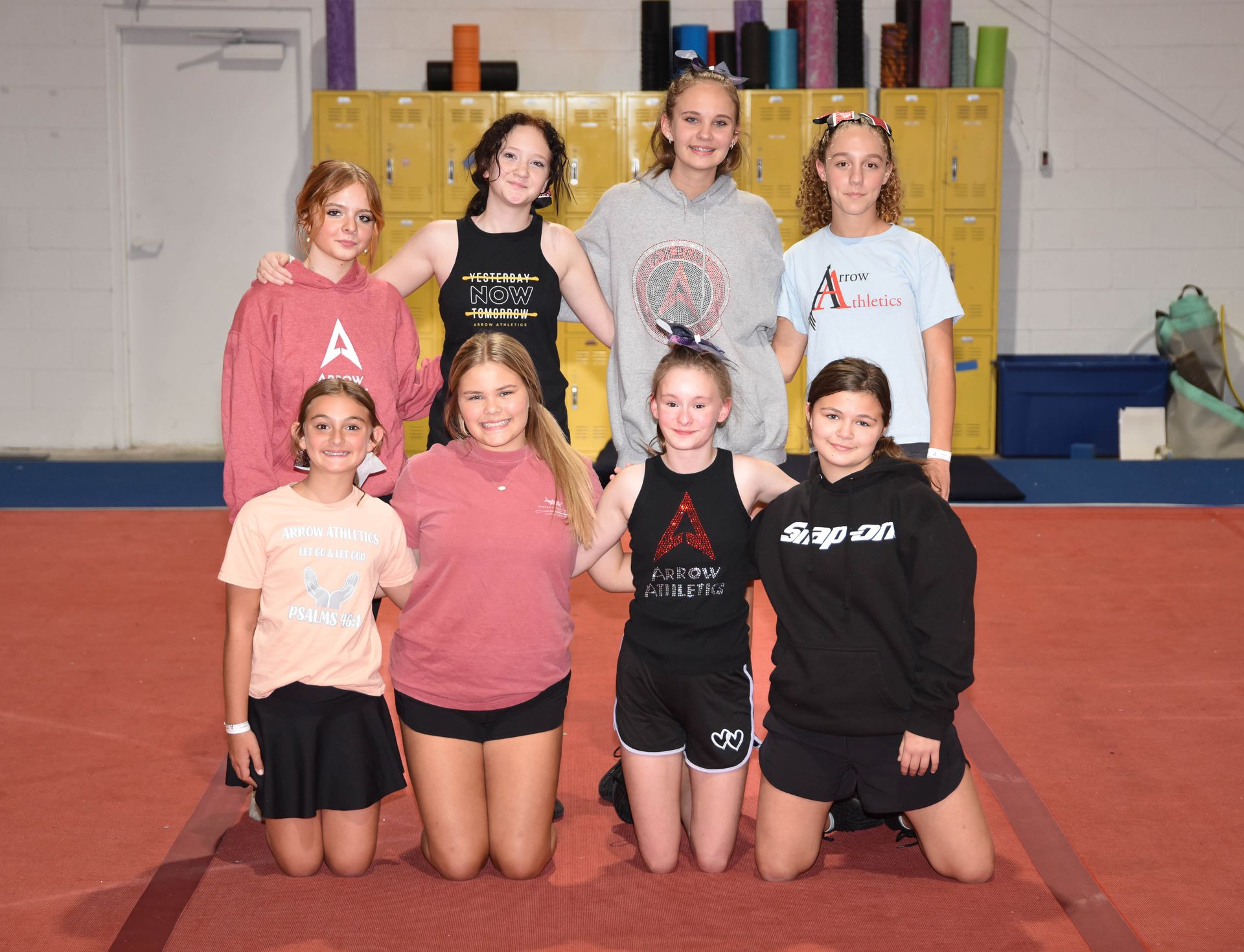 A group of young girls are posing for a picture in a gym.