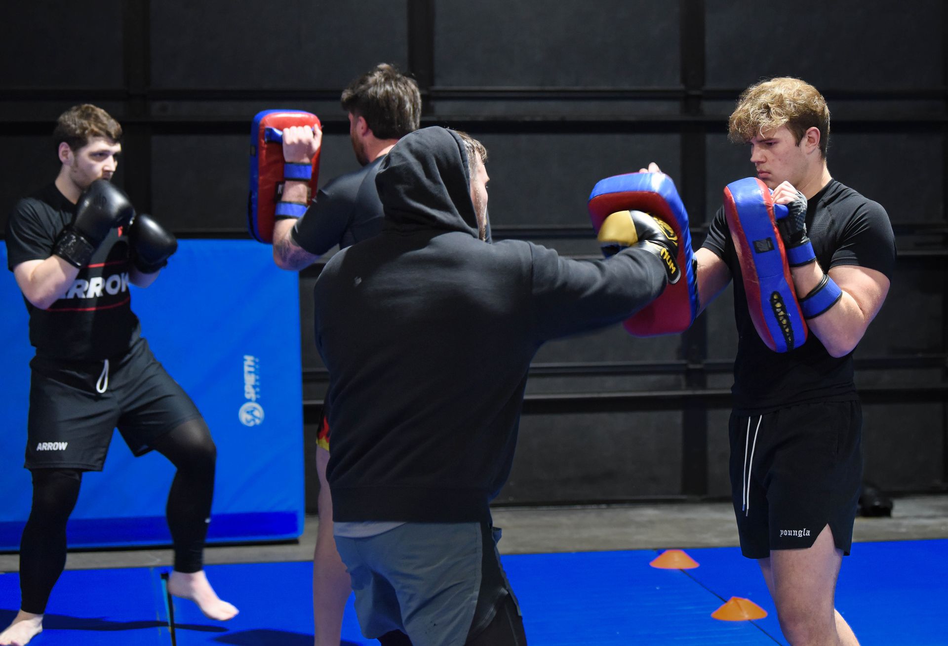 A group of young men are practicing martial arts in a gym.