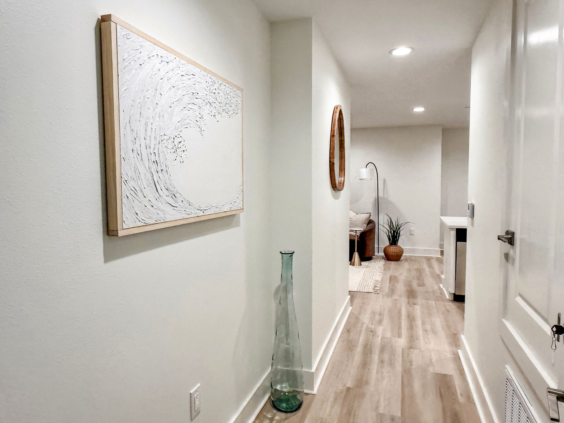 Biloxi apartment entry with wood floors and white walls opening up into the living room and kitchen area