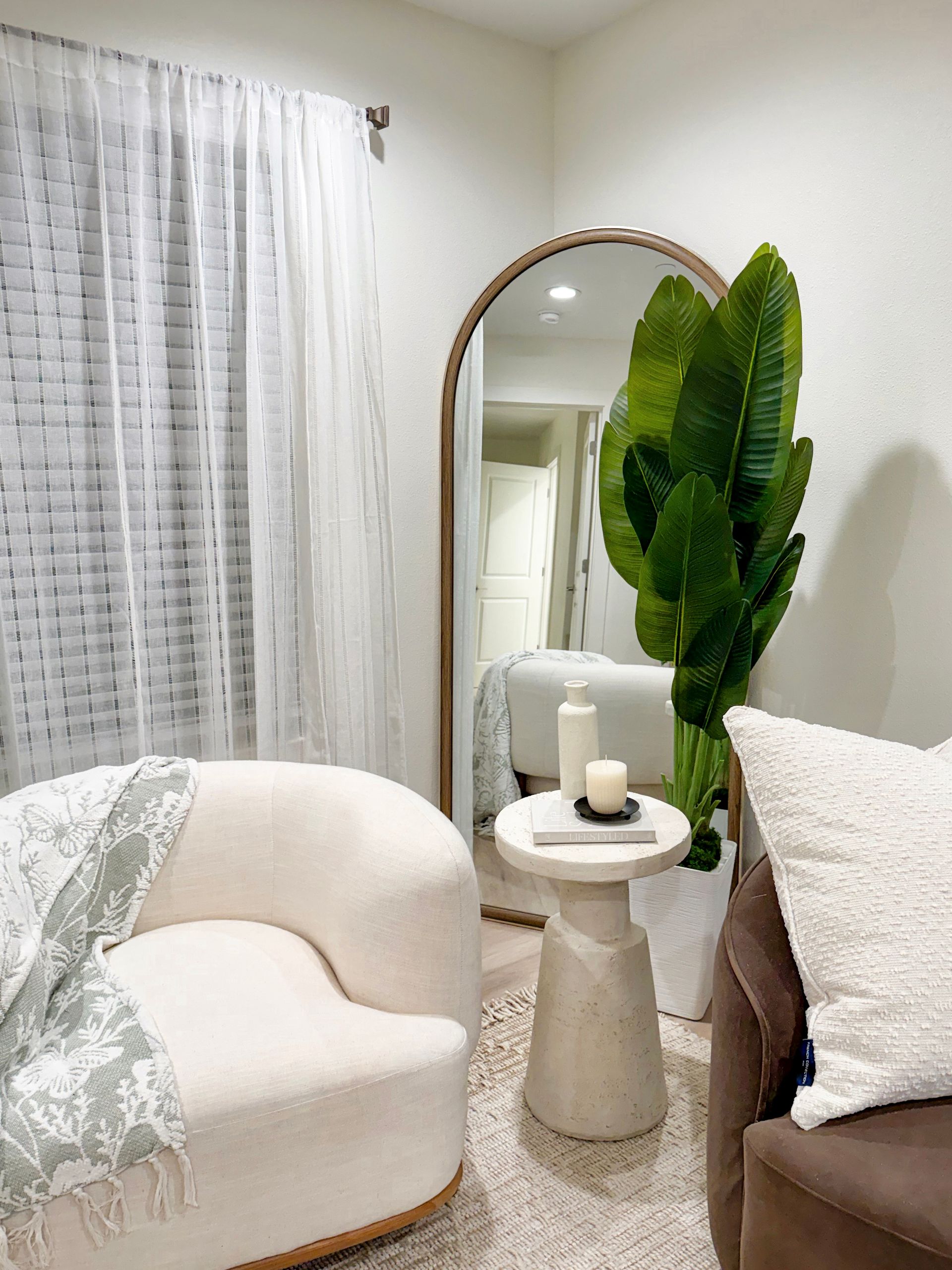 one bedroom apartment in biloxi with large mirror, plant, seating area with side table in living room