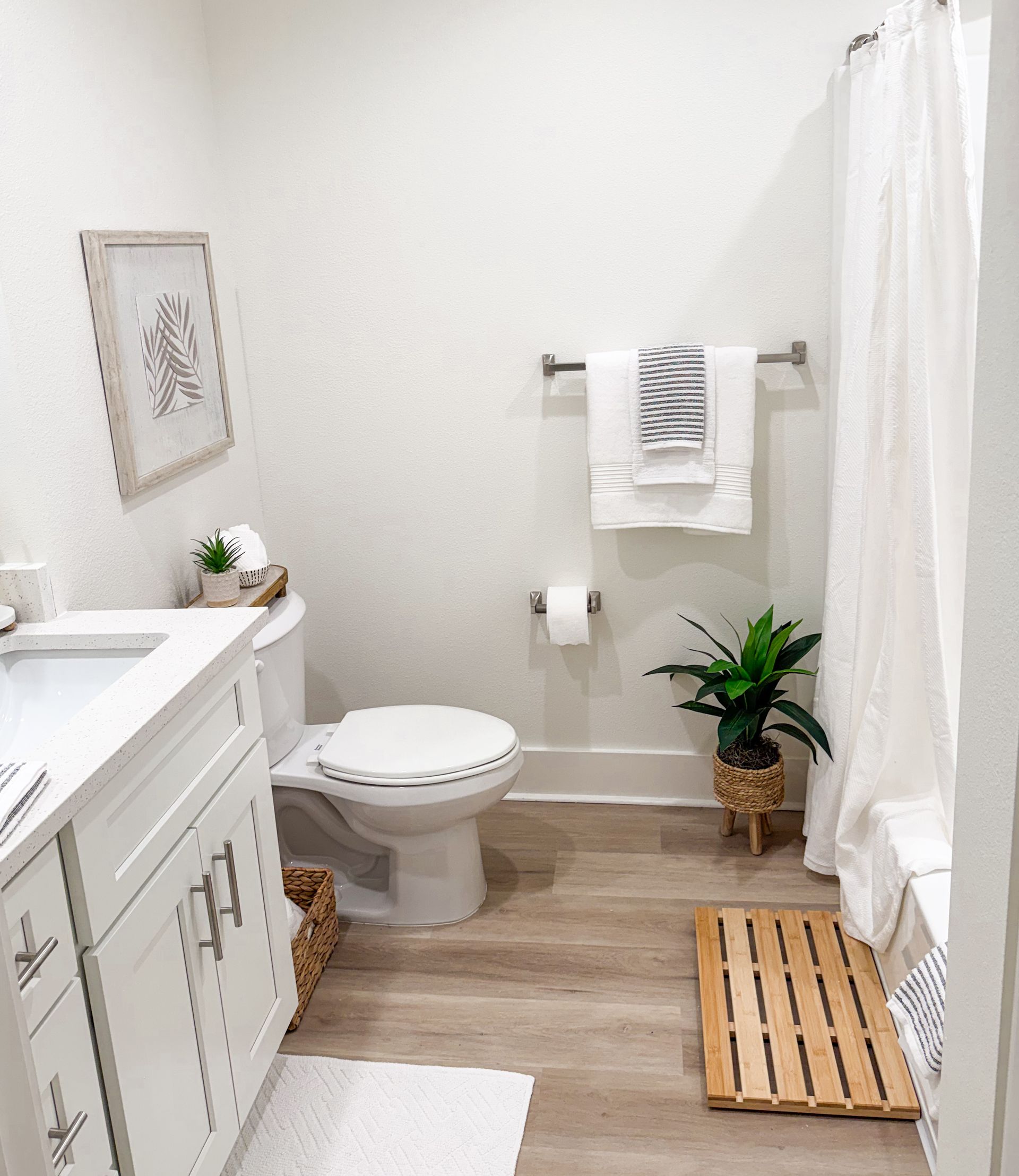 model apartment in Biloxi with quartz countertops, white and bamboo decor, and a plant 
