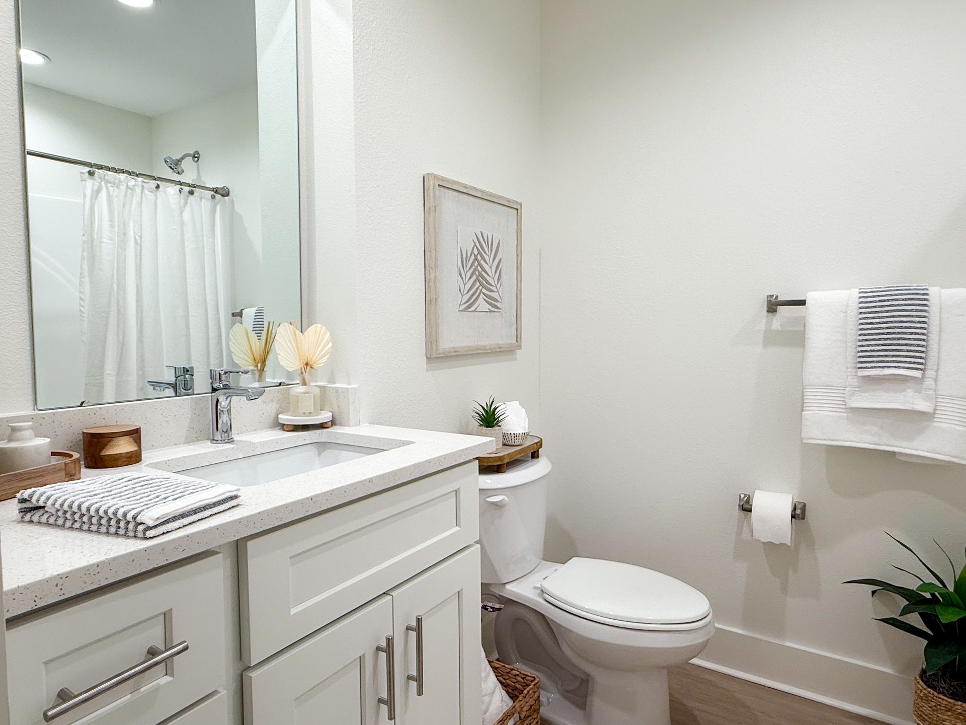 model apartment in Biloxi with quartz countertops, white and bamboo decor, and a plant 