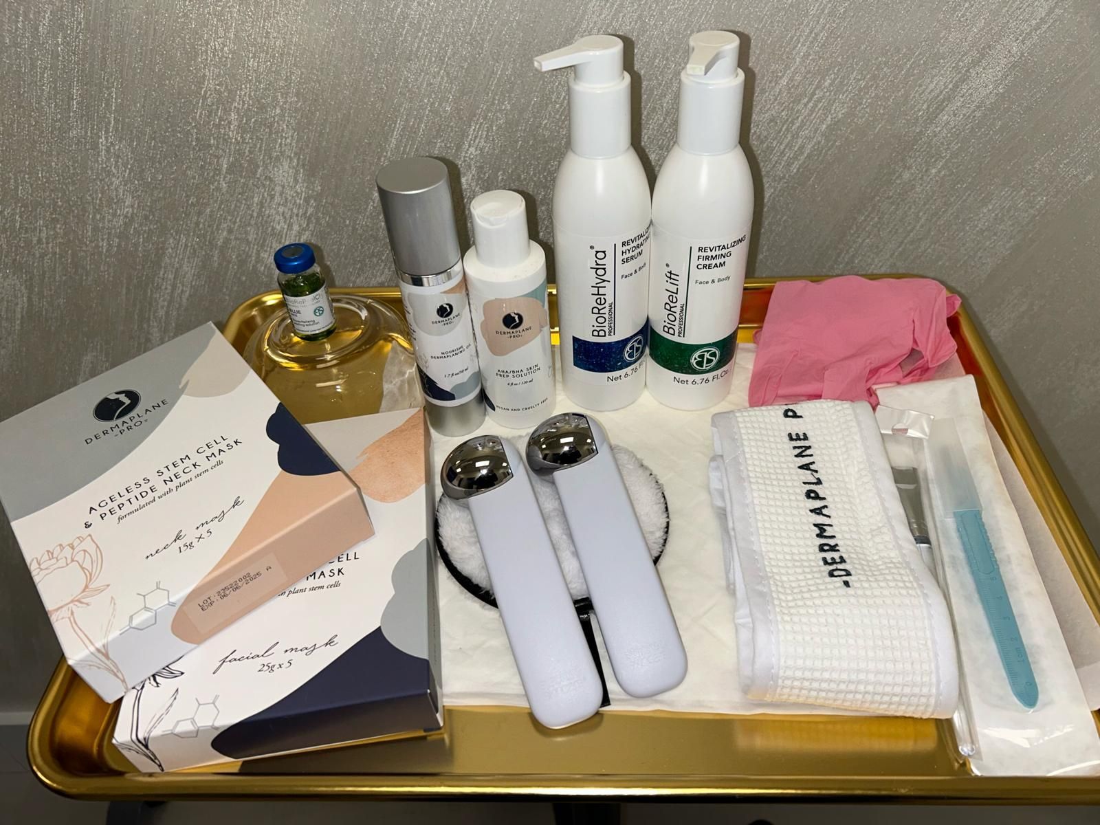 Skincare products and tools on a tray.