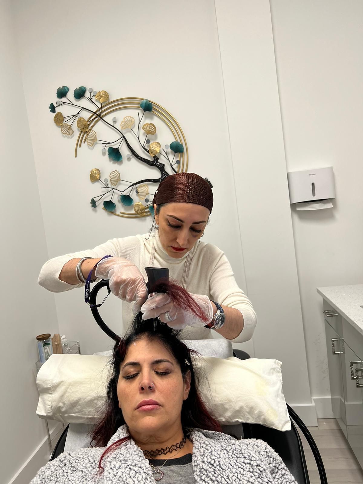 A woman is laying under a celluma light