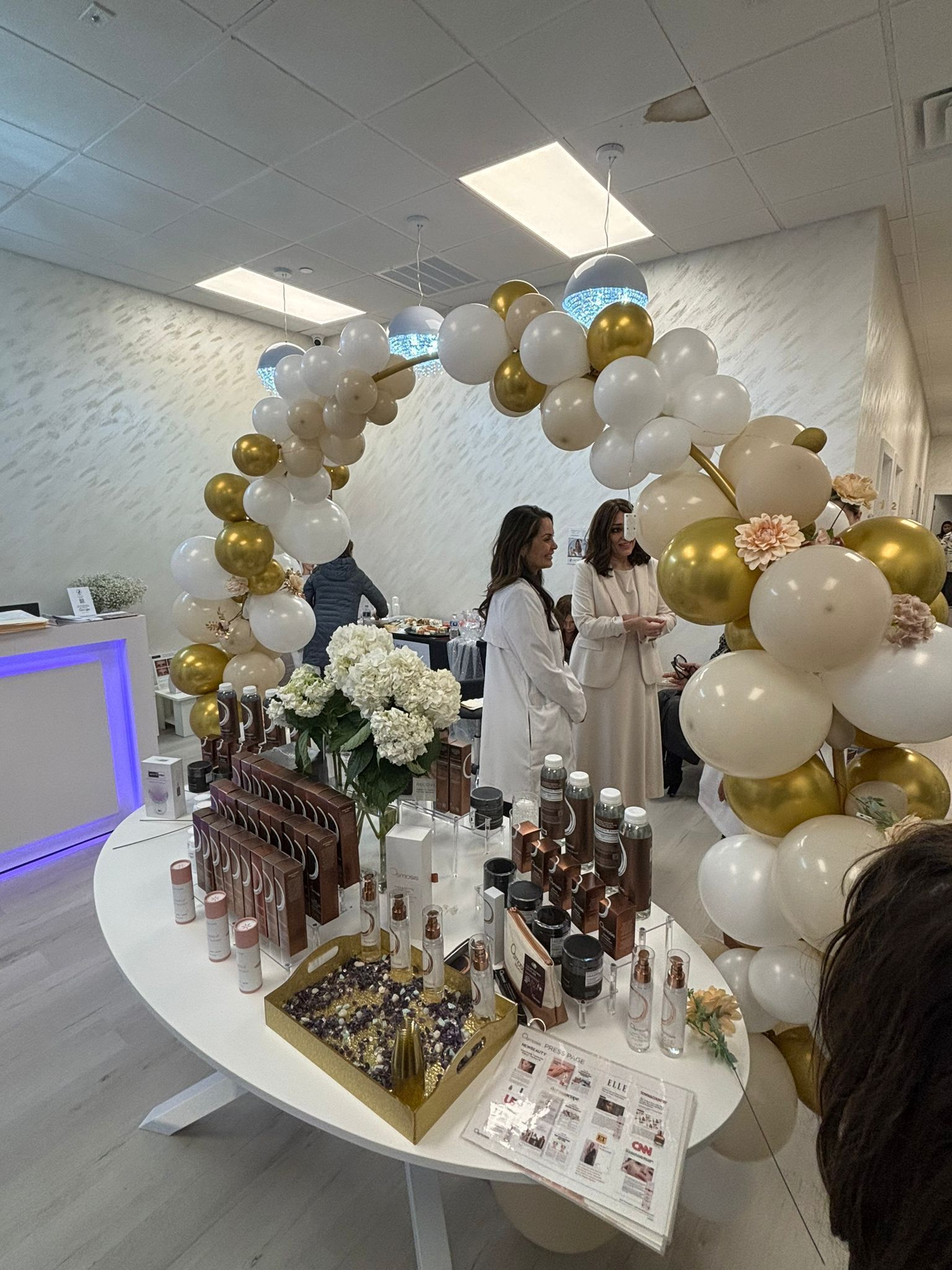 A woman is standing in front of a table with balloons on it.