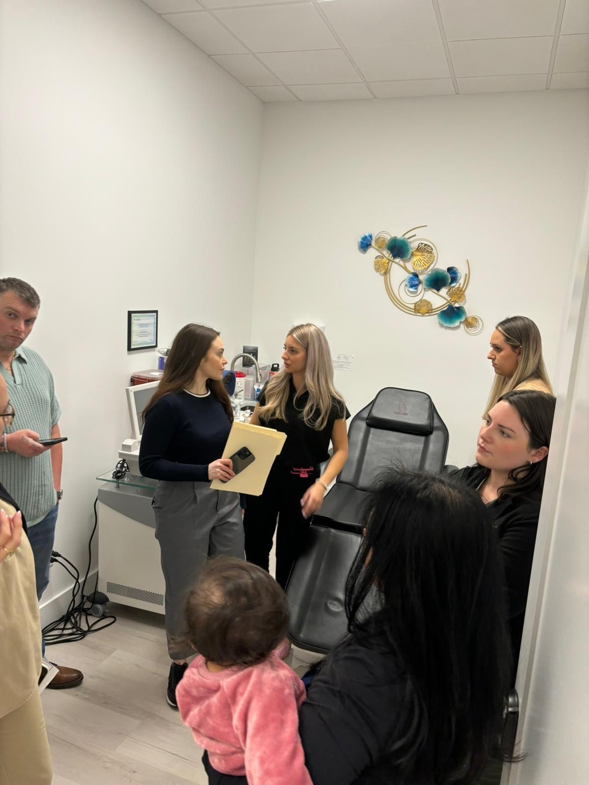 A group of people are standing in a room talking to each other.