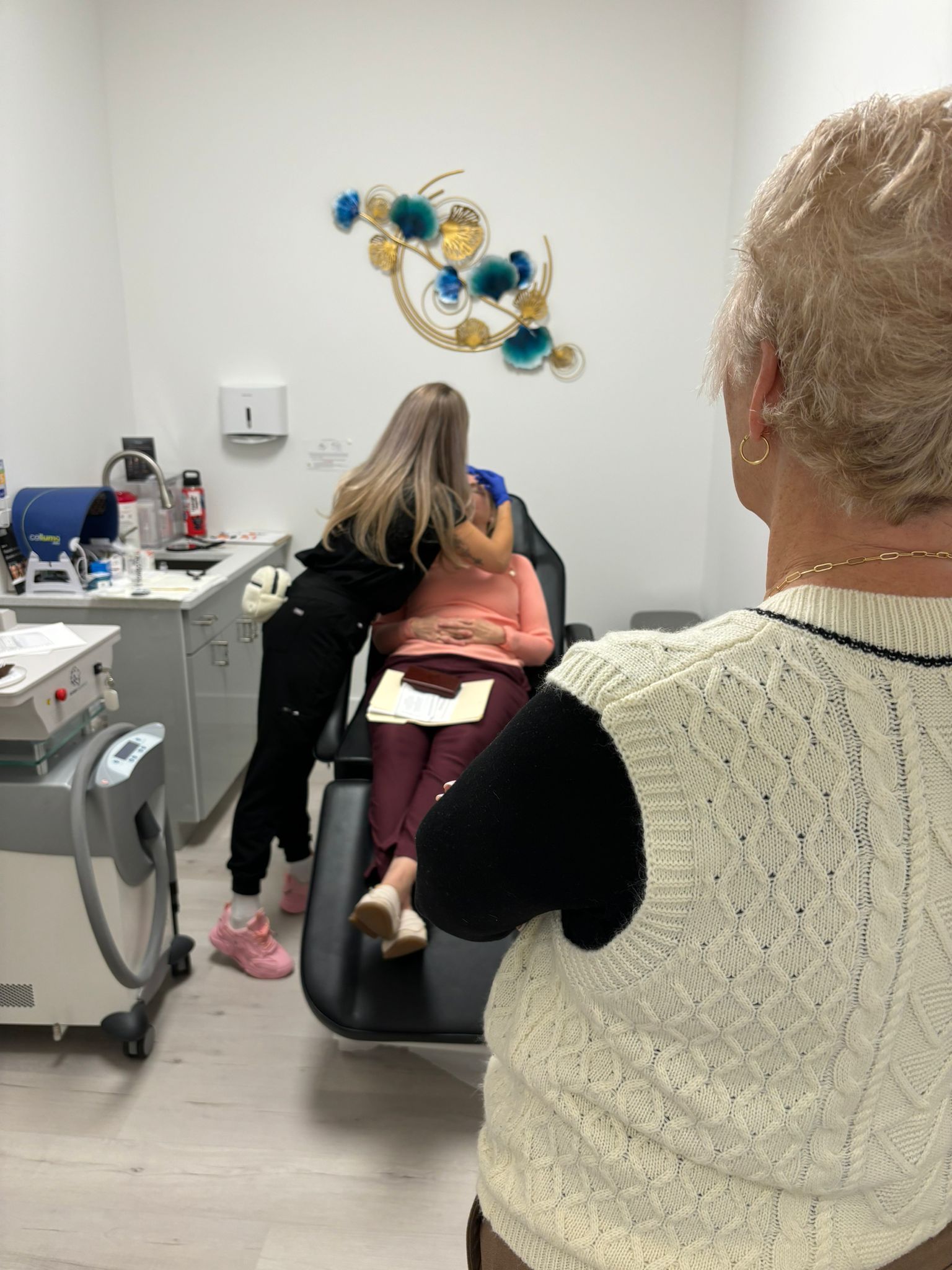 A woman is taking a picture of a woman in a dental chair.