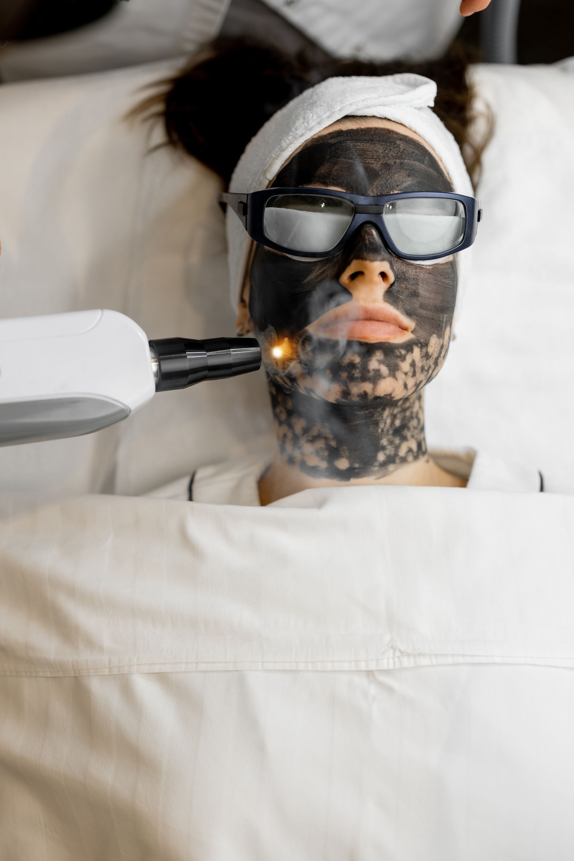 A woman is getting a laser treatment on her face.