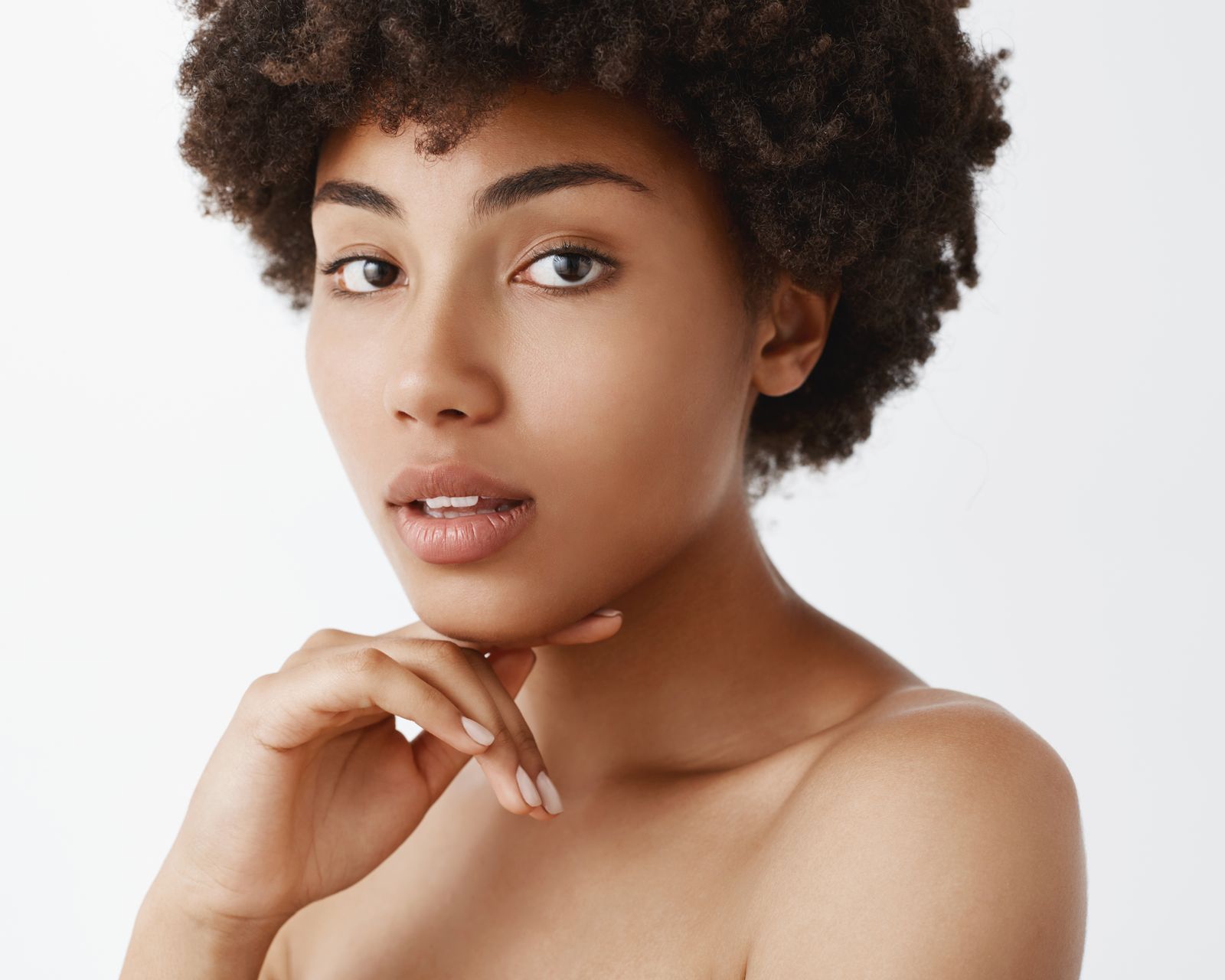 A close up of a woman 's face with her hand on her chin.