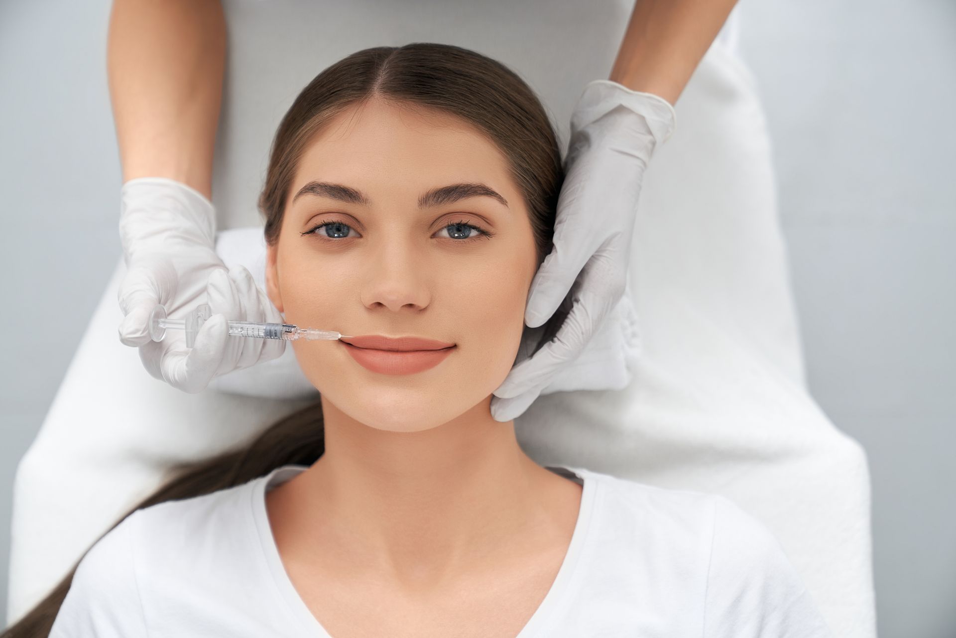 A woman is getting a botox injection in her face.