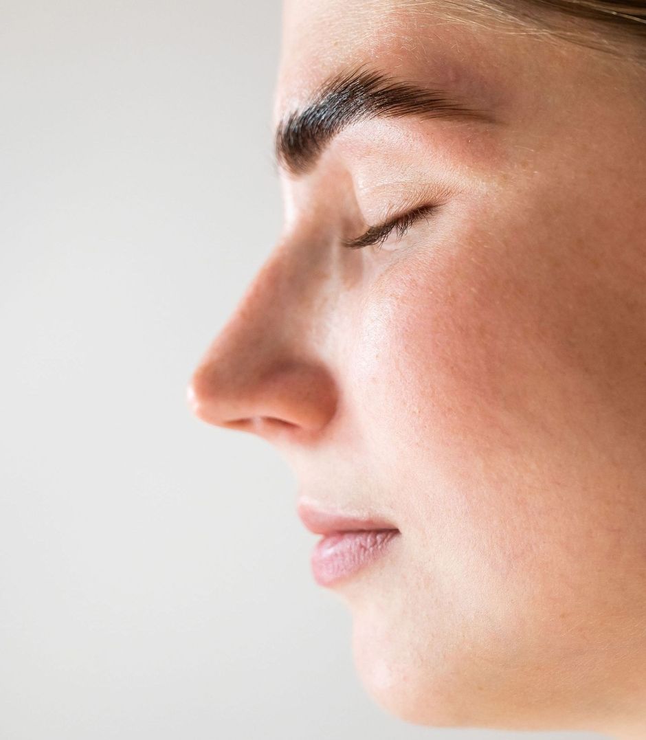 A close up of a woman 's face with her eyes closed.