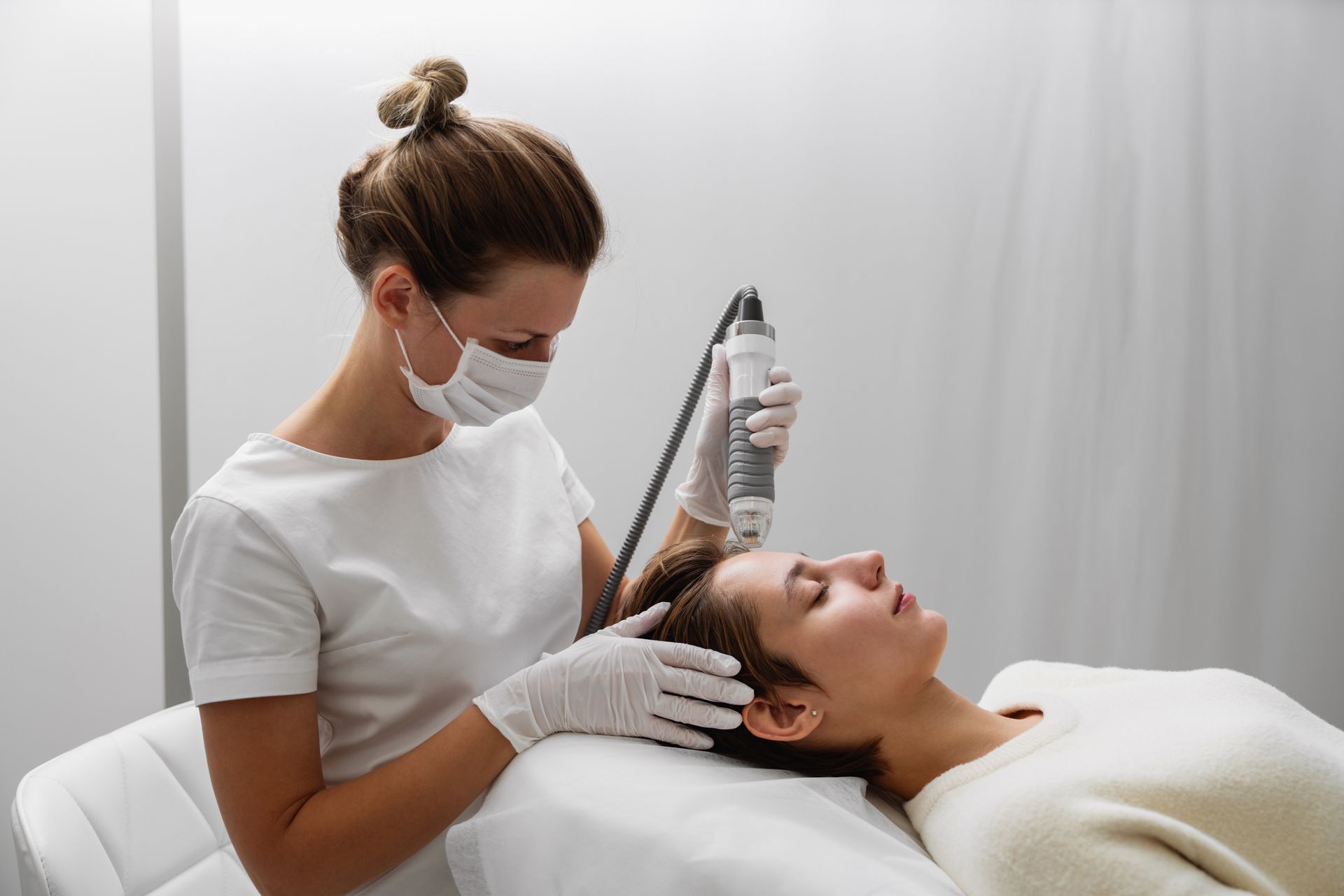 A woman is getting a hair treatment at a beauty salon.