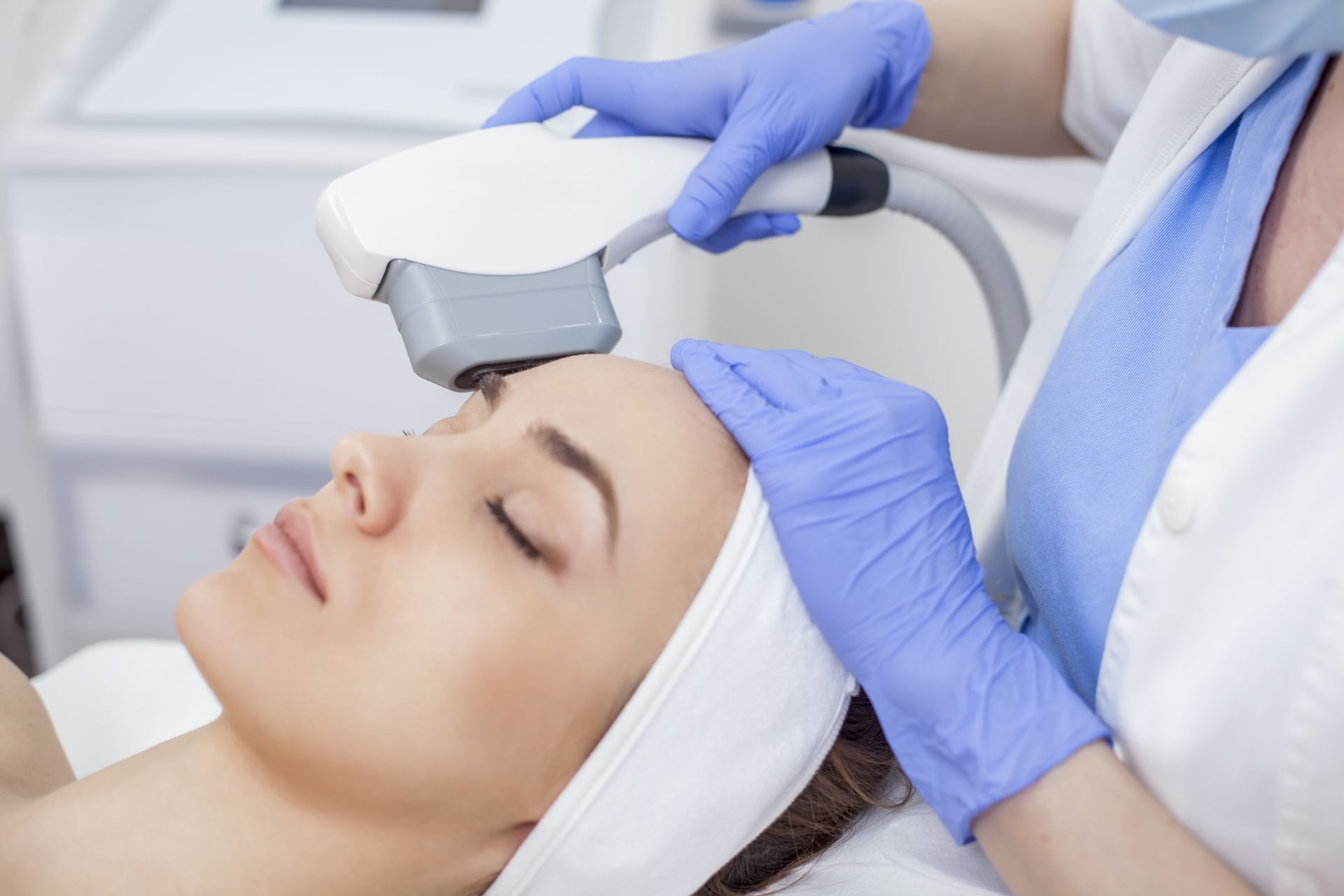 A woman is getting a laser treatment on her face.