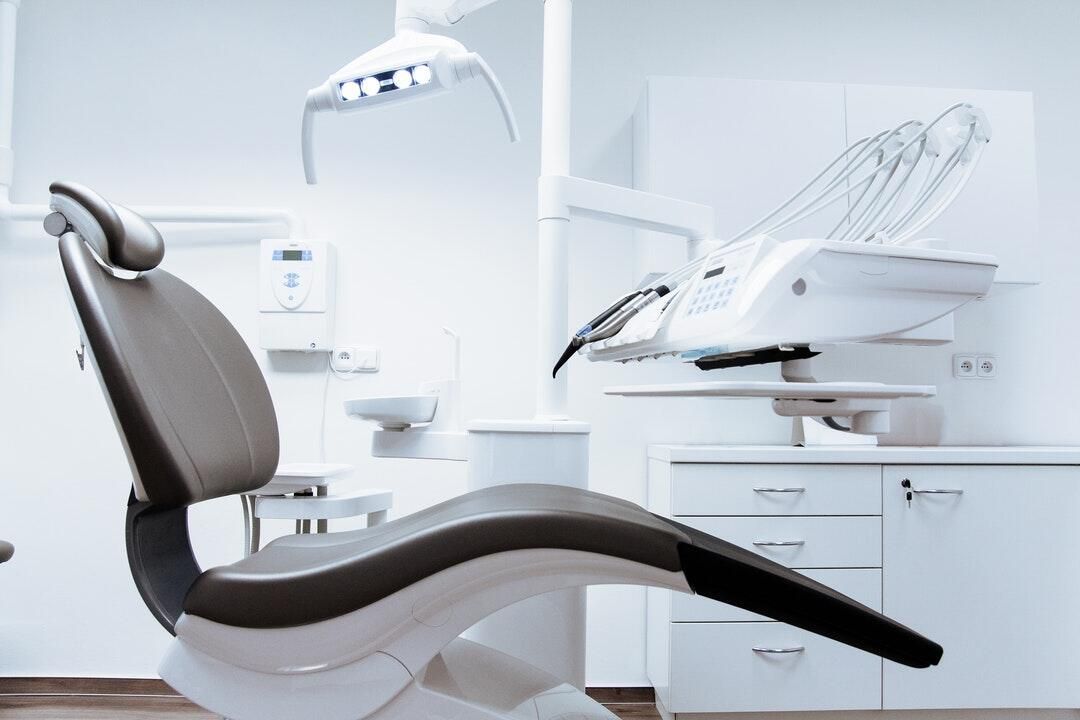 A dental chair is sitting in a dental office.