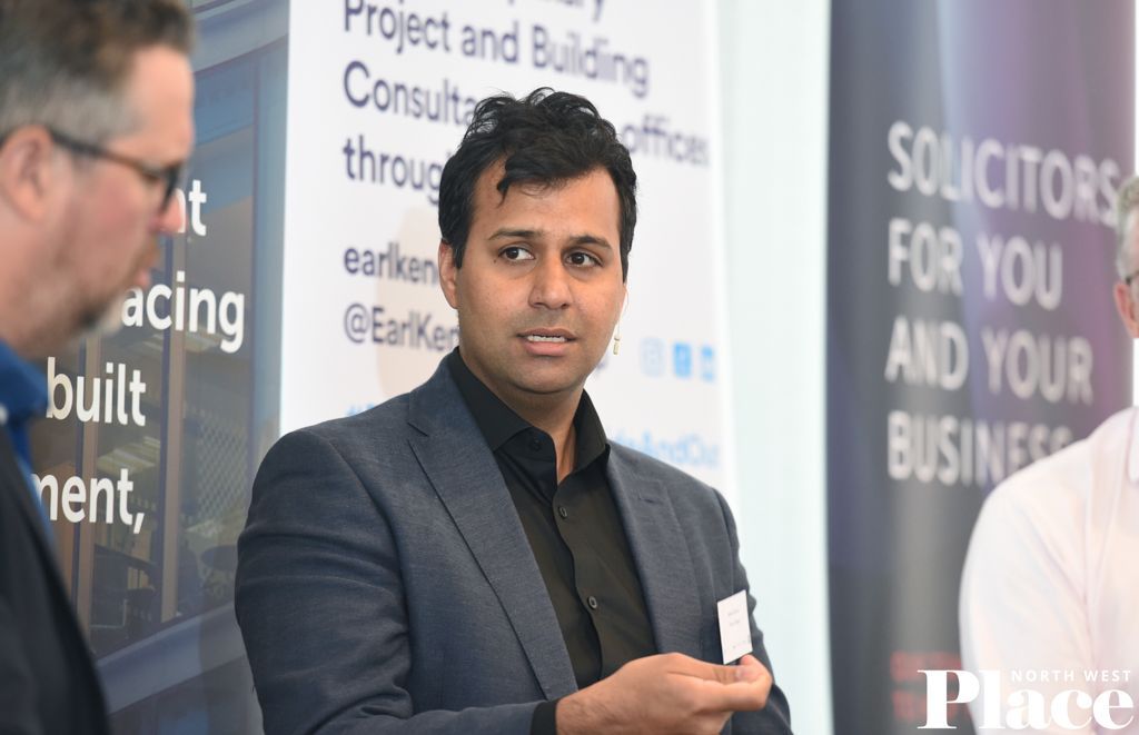 A man in a suit is standing in front of a sign that says solicitors for you and your business