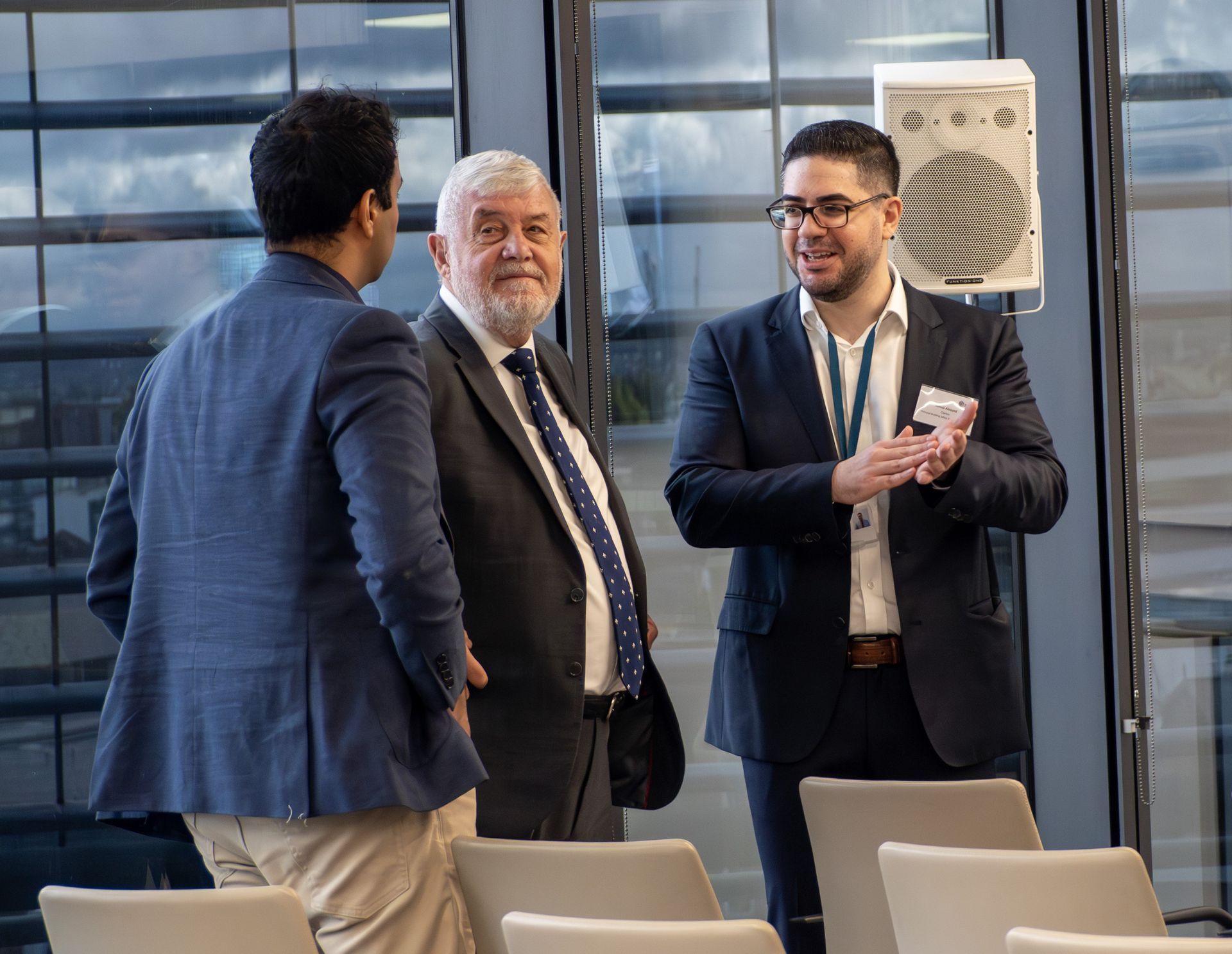 A group of people are standing together talking.