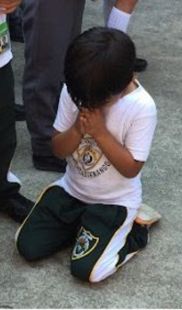 A little impoverished Guatemalan boy that is 5-years-old is kneeling down to pray for his family. 