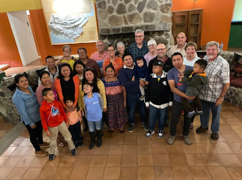 A large group of people are posing for a picture in a room.