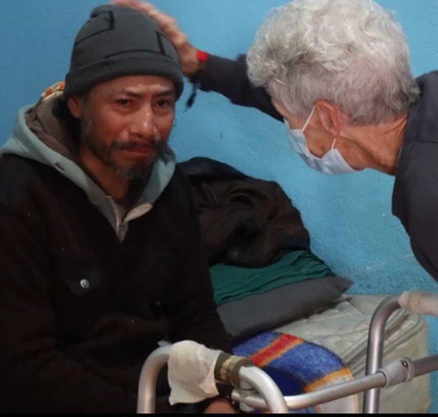 Nurse Nancy praying with a poor Guatemalan man after giving him a health screening and much-needed healthcare for an infection