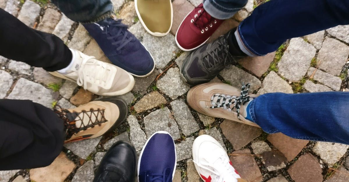 A group of people are standing in a circle on a cobblestone street.