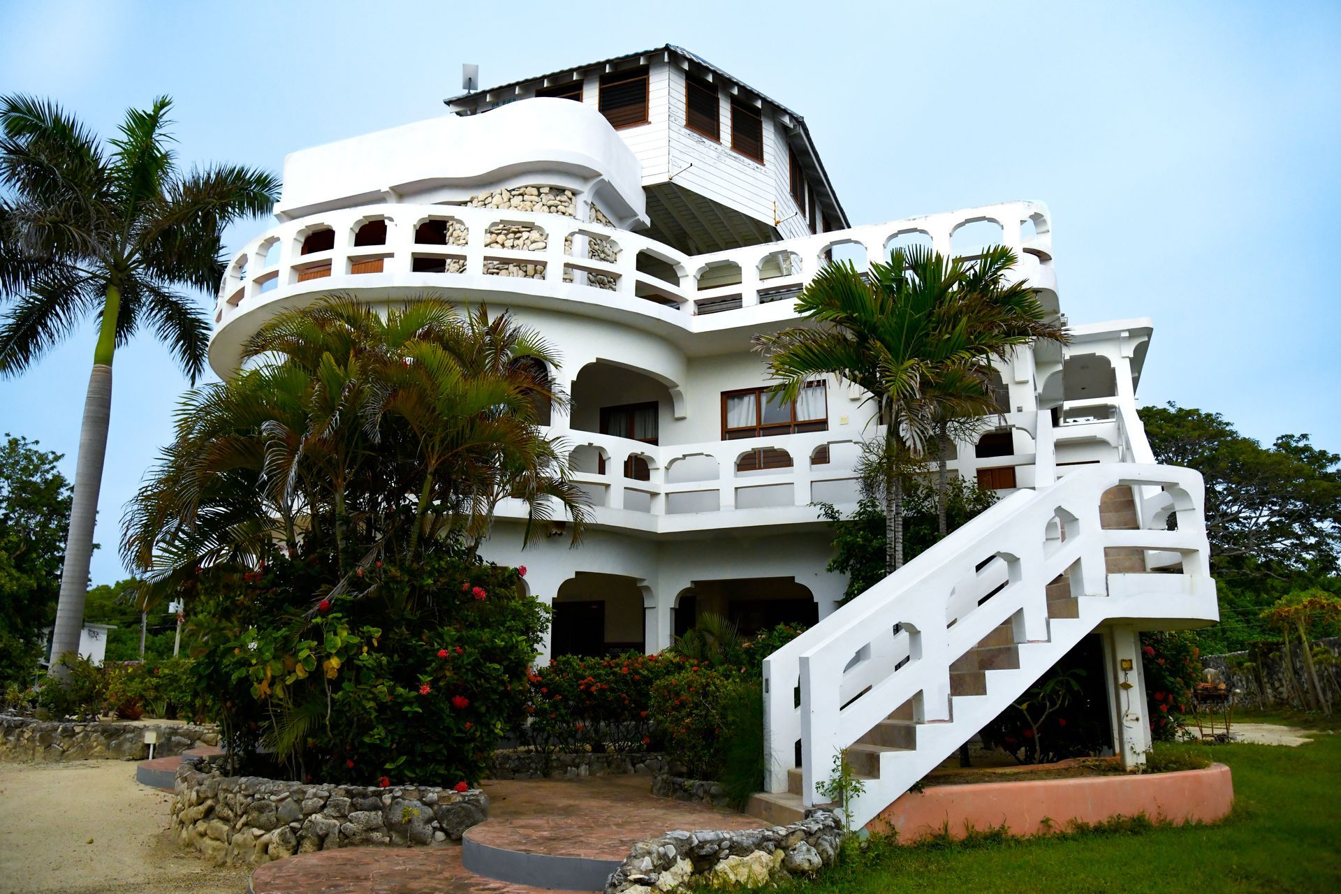 A large white house with stairs leading up to the second floor