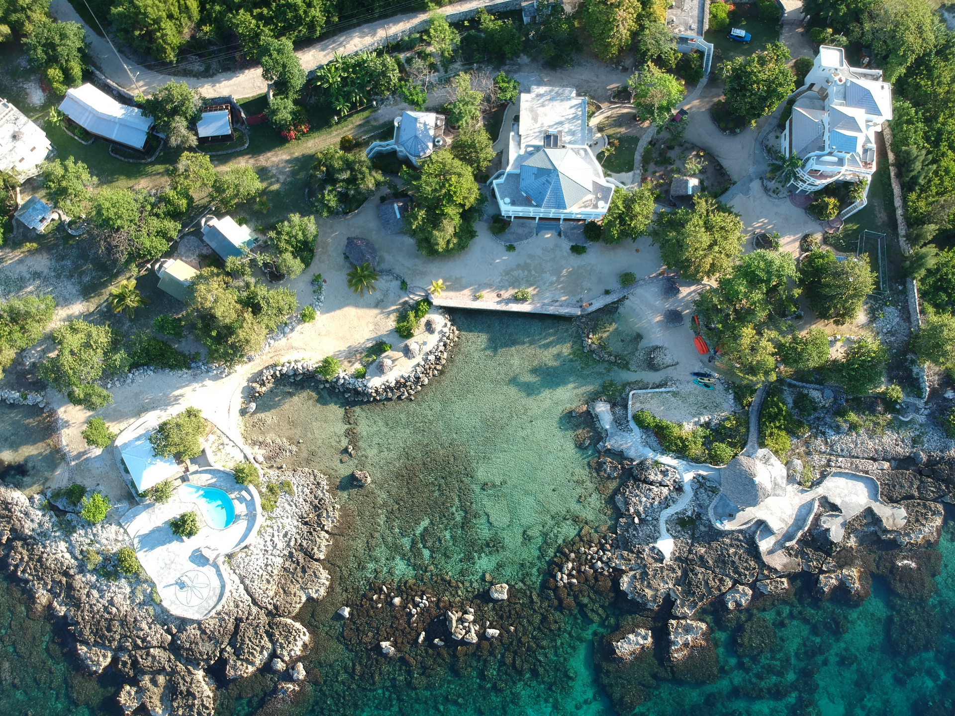 An aerial view of a tropical island with houses and trees