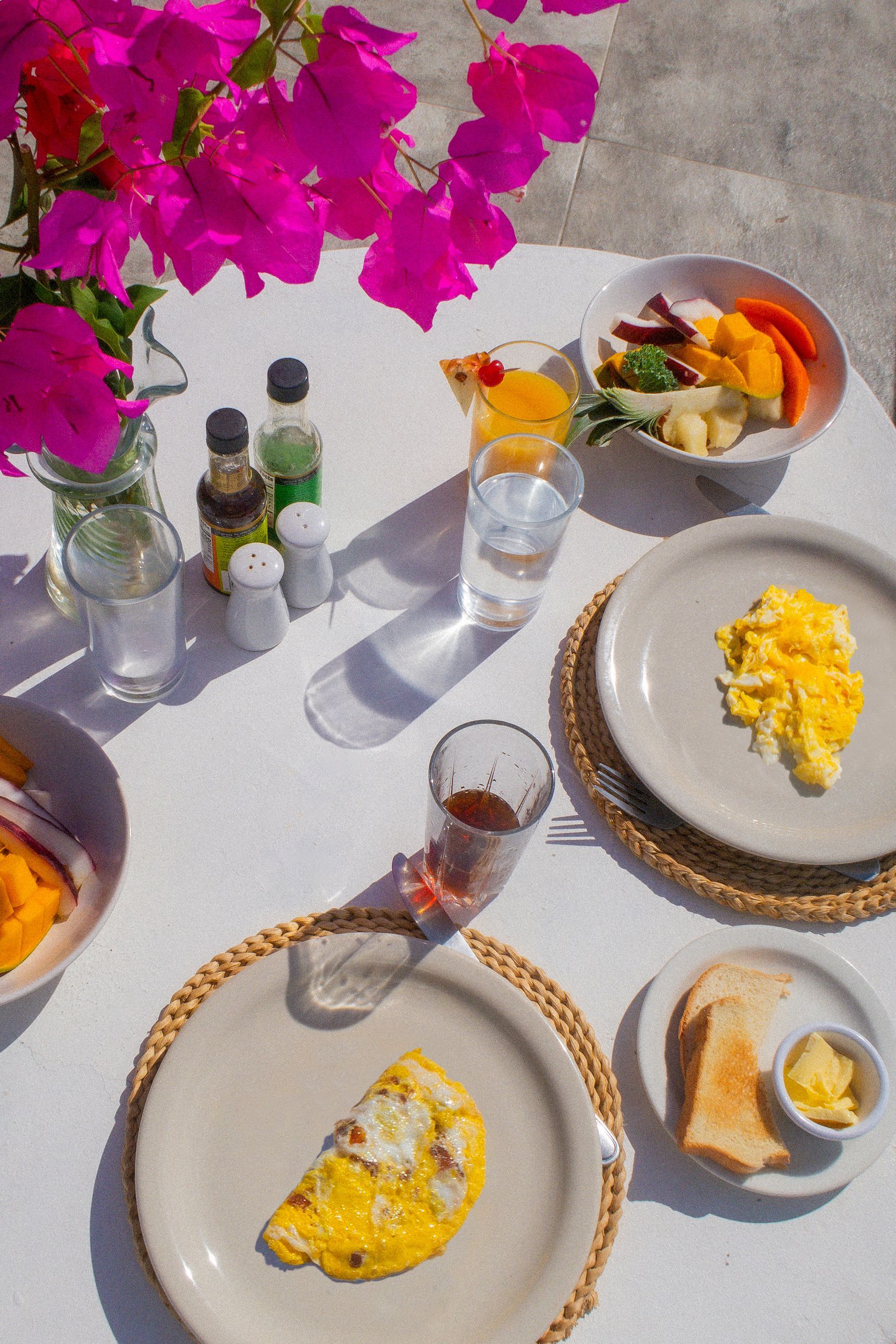 A table topped with plates of food and a vase of flowers.