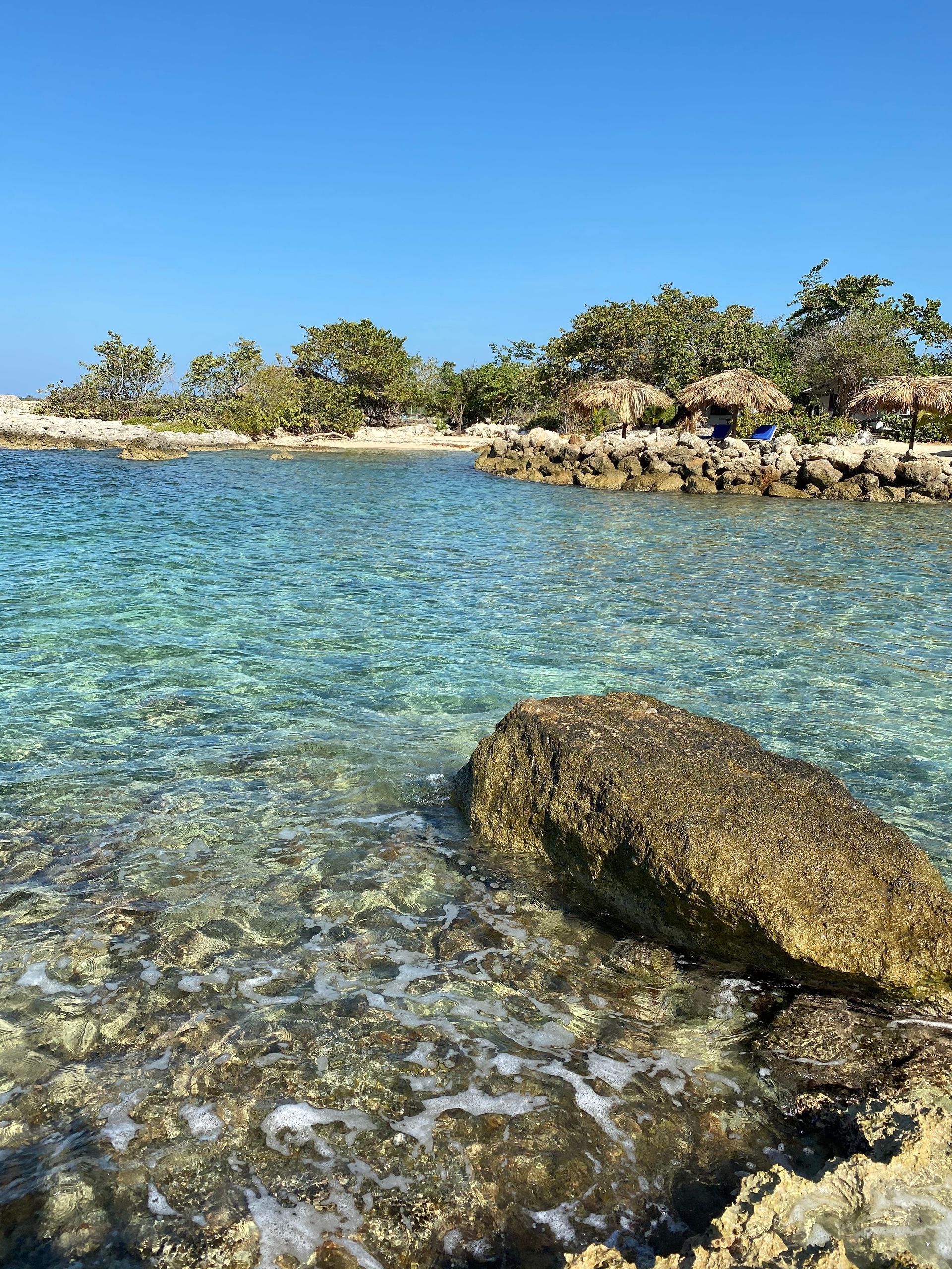 A large rock is in the middle of a body of water.