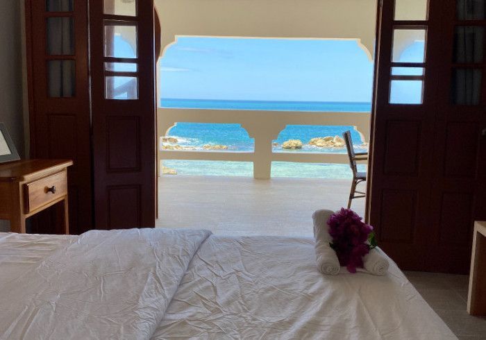 A bedroom with a bed and a view of the ocean