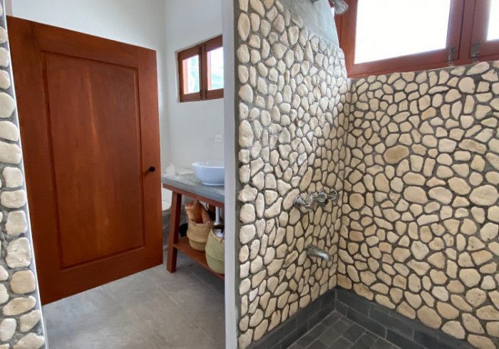 A bathroom with a stone wall and a sink