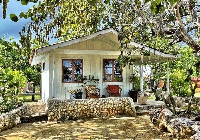 A small white house with a porch and chairs