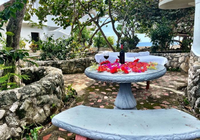 A table with flowers on it and a bottle of wine on it.