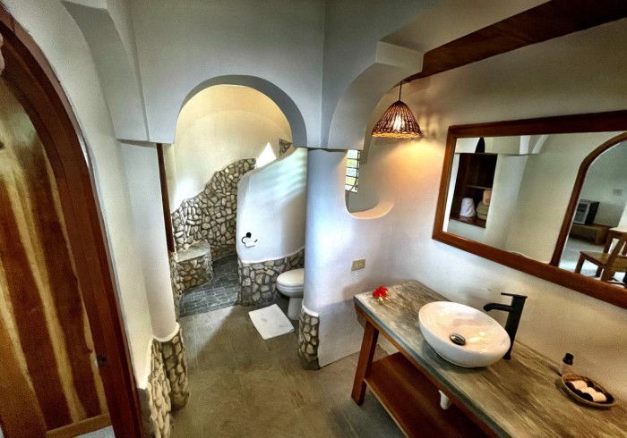 A bathroom with a sink , mirror and toilet.