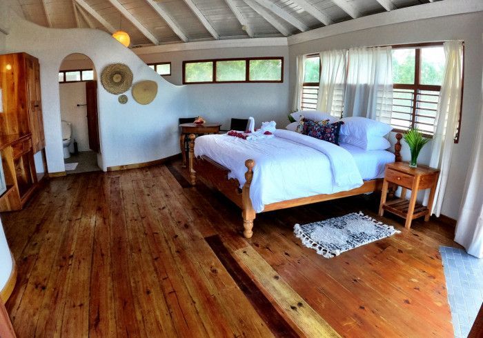 A bedroom with a large bed and wooden floors