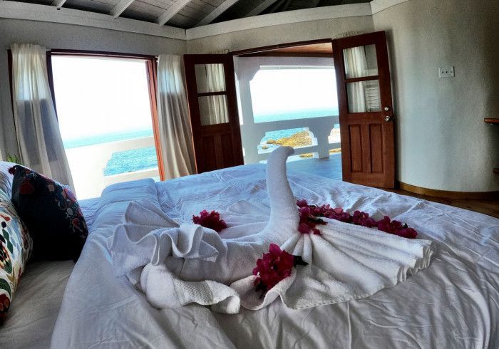 A bed with a swan made out of towels and flowers