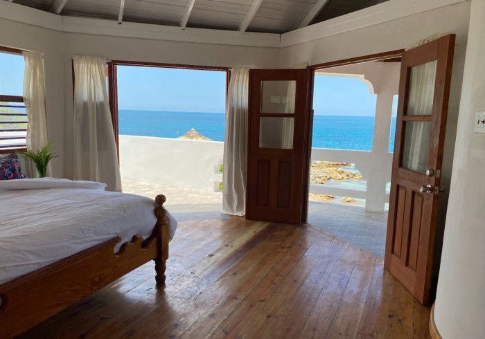 A bedroom with a bed and a view of the ocean.