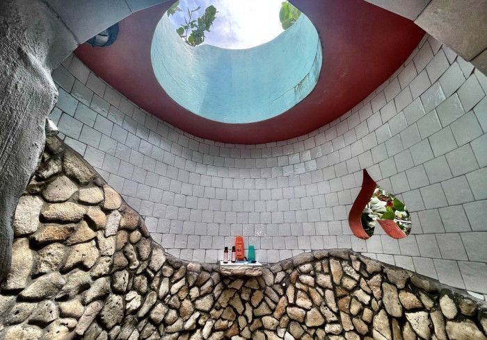 A bathroom with a stone wall and a skylight in the ceiling