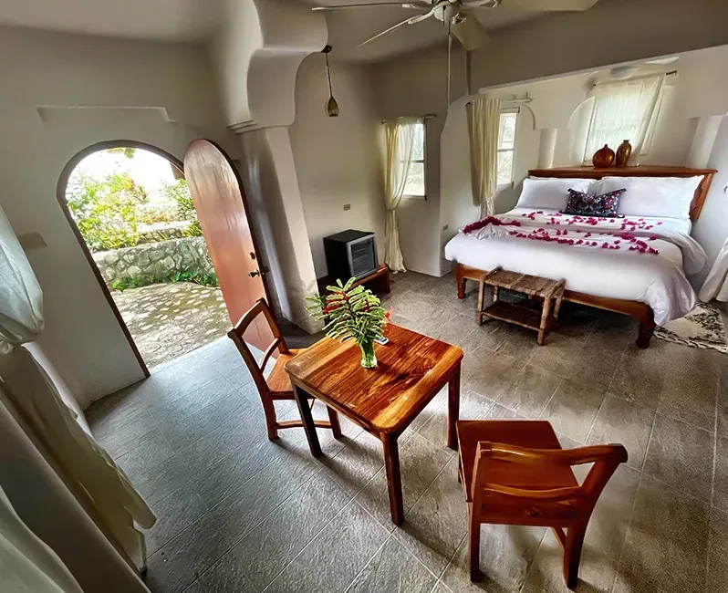 A bedroom with a king size bed and a table and chairs