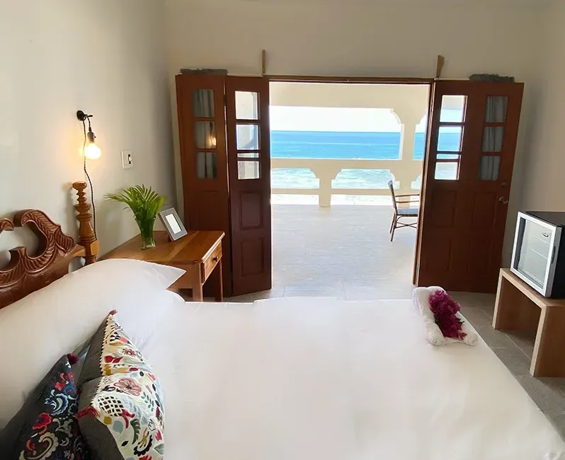 A bedroom with a king size bed and a view of the ocean
