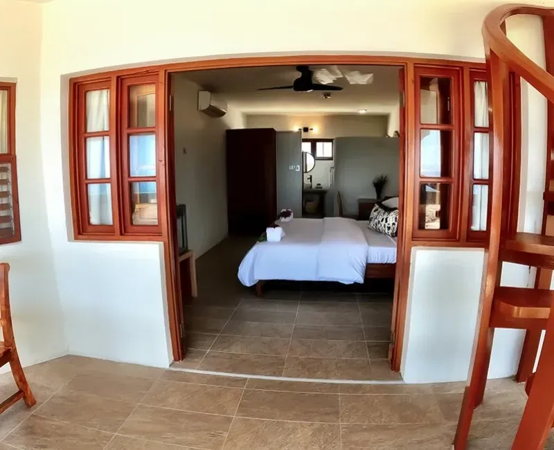 A bedroom with a bed and stairs leading up to it