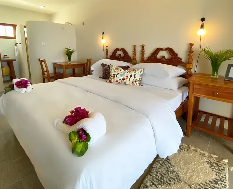 A bed with white sheets and flowers on it