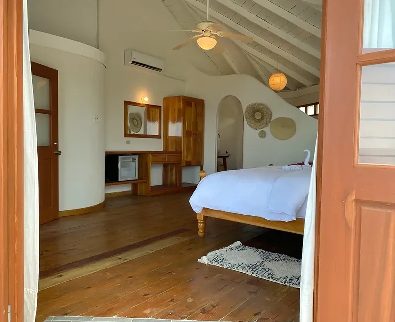 A bedroom with a bed and a ceiling fan