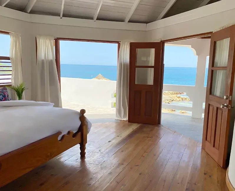 A bedroom with a bed and a view of the ocean