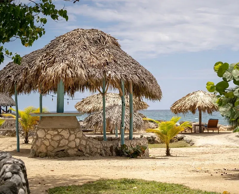 A gazebo with a thatched roof on a beach