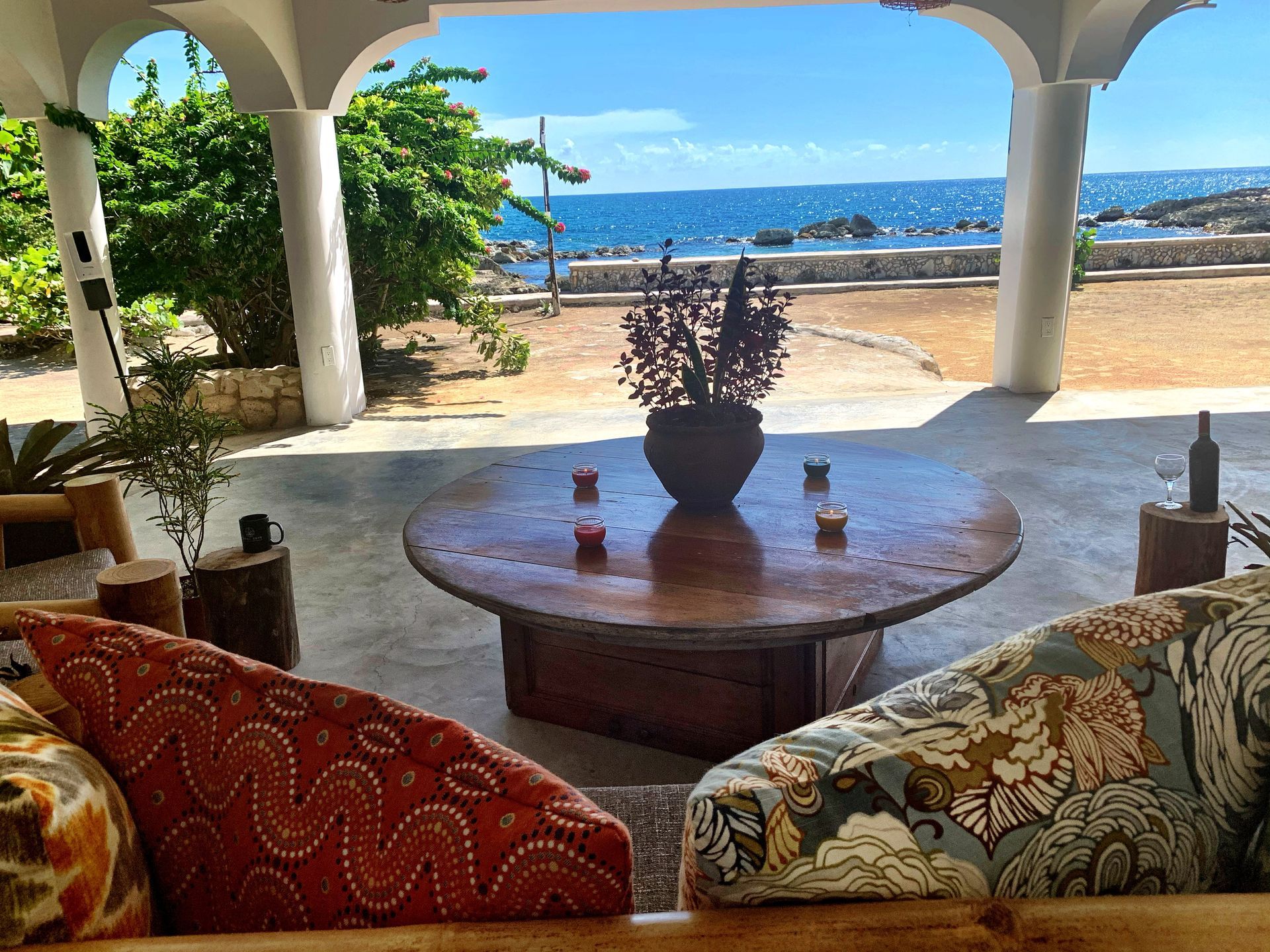 A living room with a table and chairs and a view of the ocean