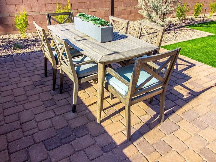 A paved backyard patio with a dining table.