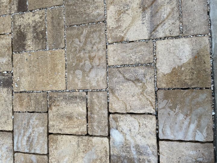 A modern patio with a dining table and outdoor kitchen leading into an open-plan kitchen and living room.