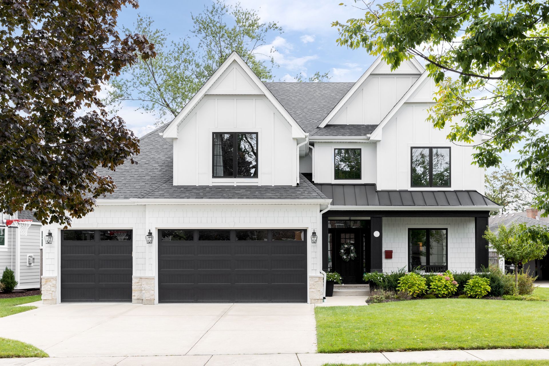 Two-story modern farmhouse with white board-and-batten siding.