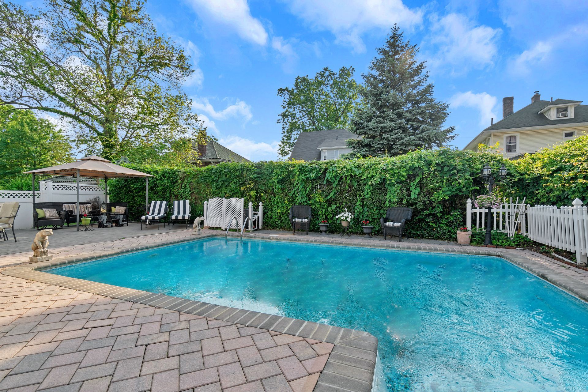 A sunny backyard featuring an in-ground pool.