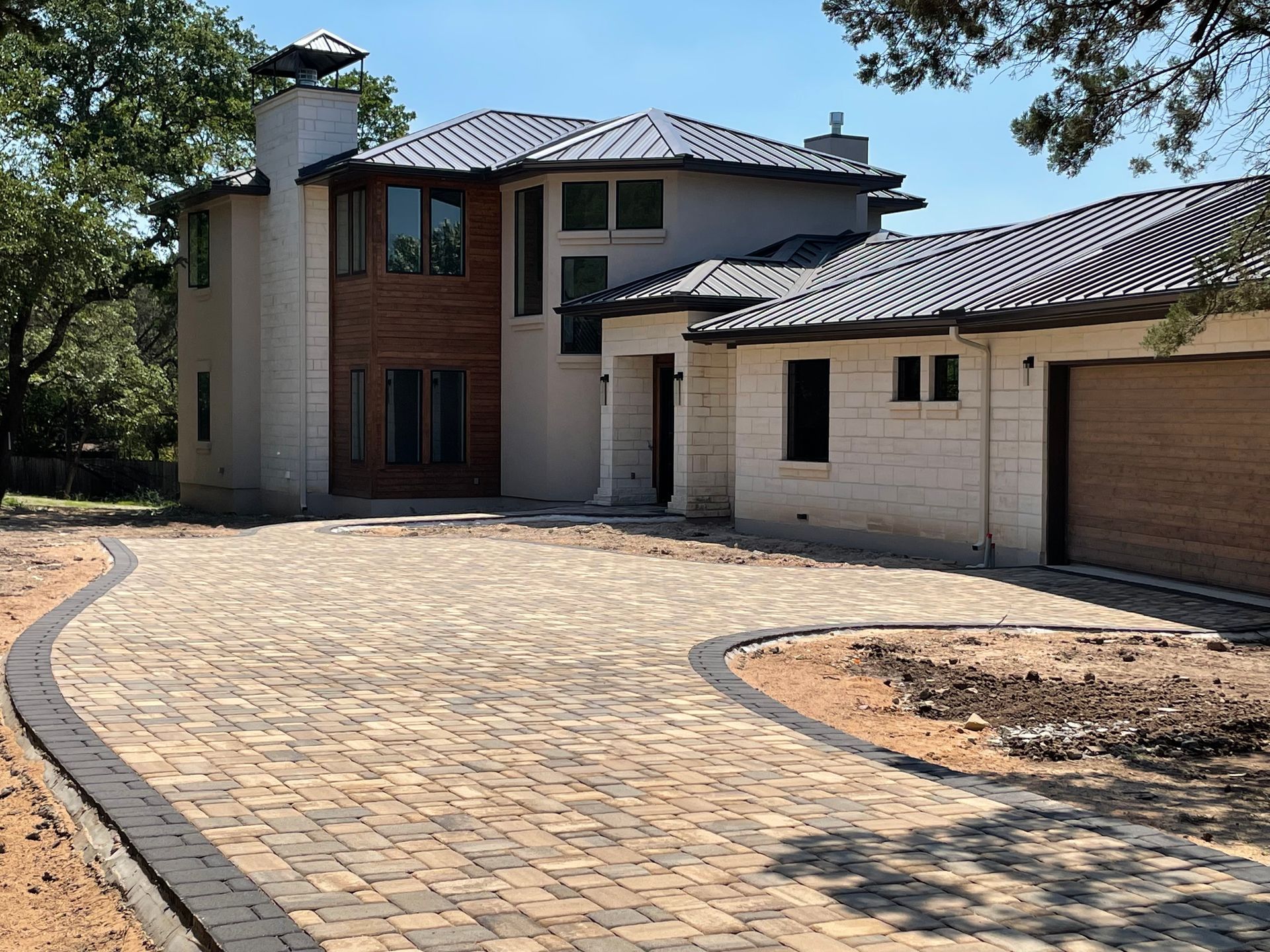 A modern two-story home with a tan stone and wood exterior.